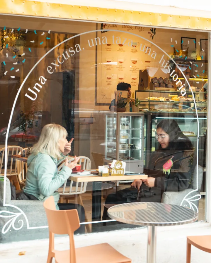 La vidriera de Fiumi con clientes adentro y la frase “Una excusa, una taza, una historia”